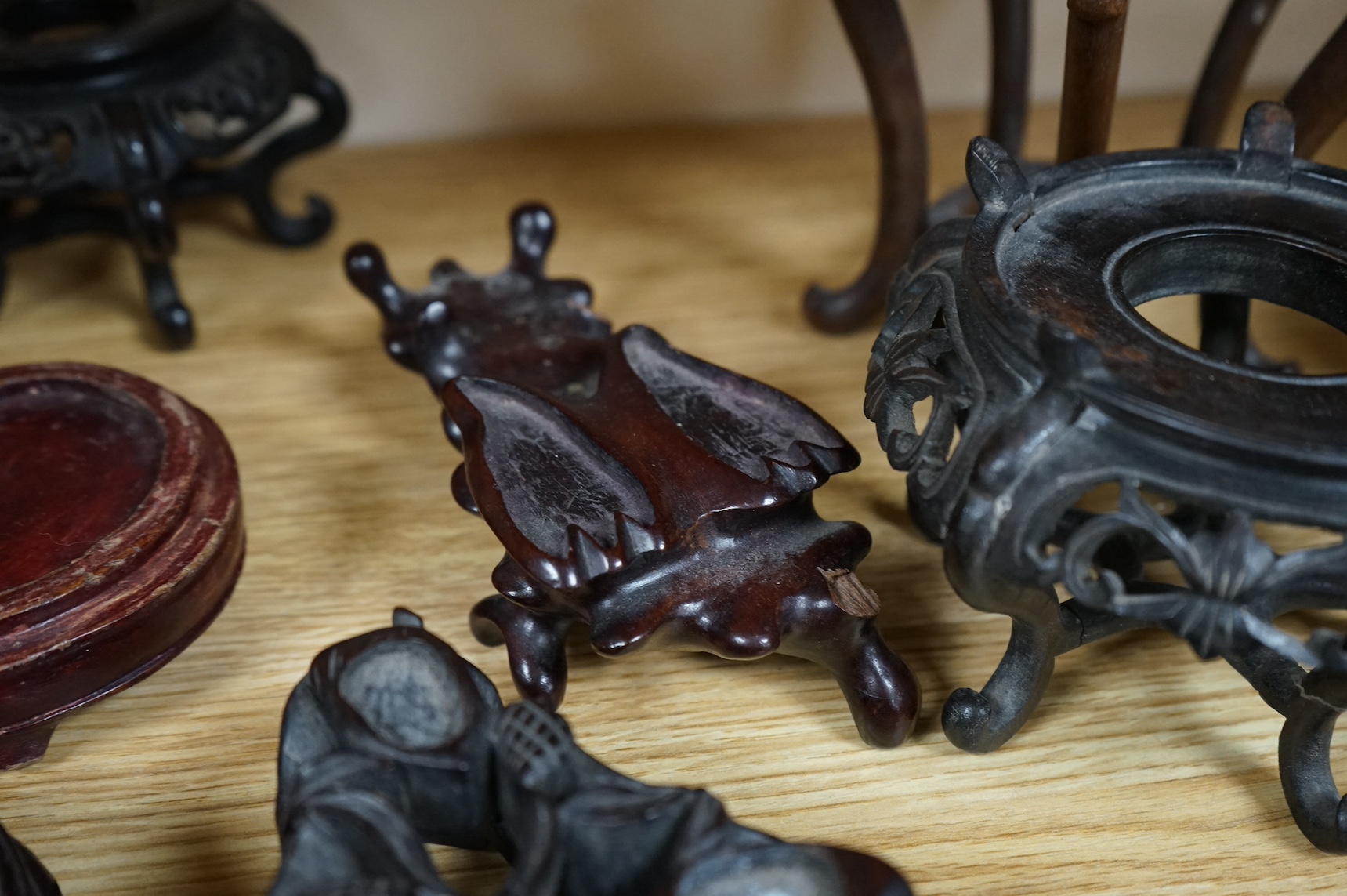 A collection of fifteen Chinese and Japanese carved hardwood stands, tallest 15.5cm. Condition - fair to good